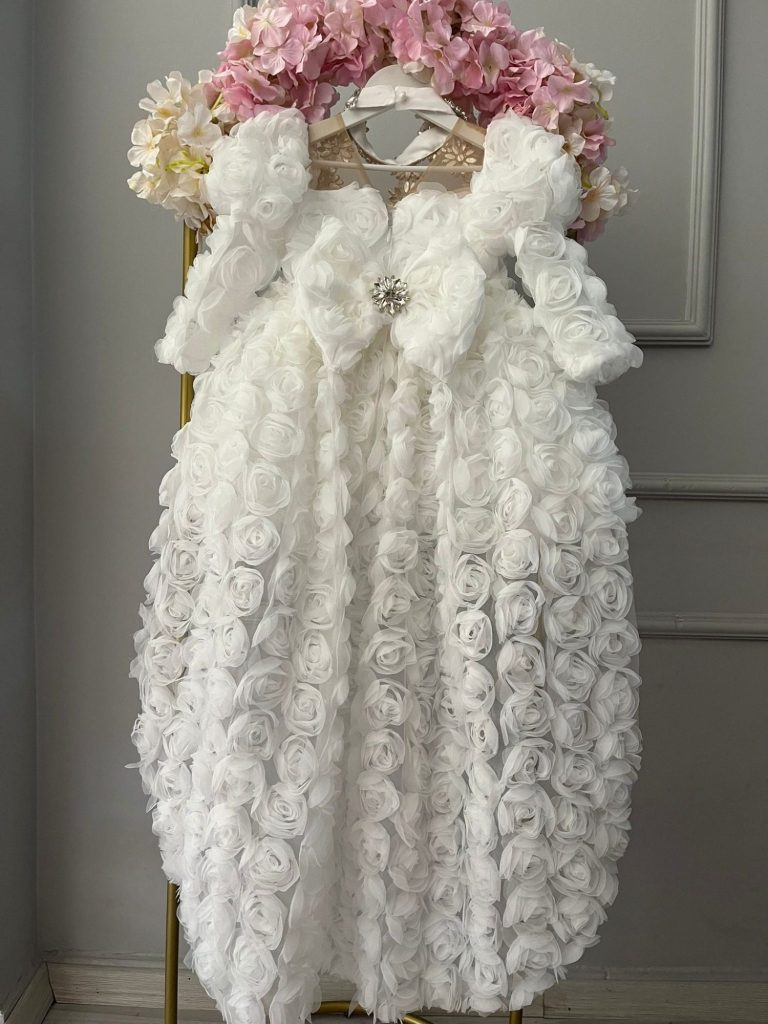 Vestido niña blanco comunión con flores 3D volumétricas, rosas tul y tren asimétrico corto delante.